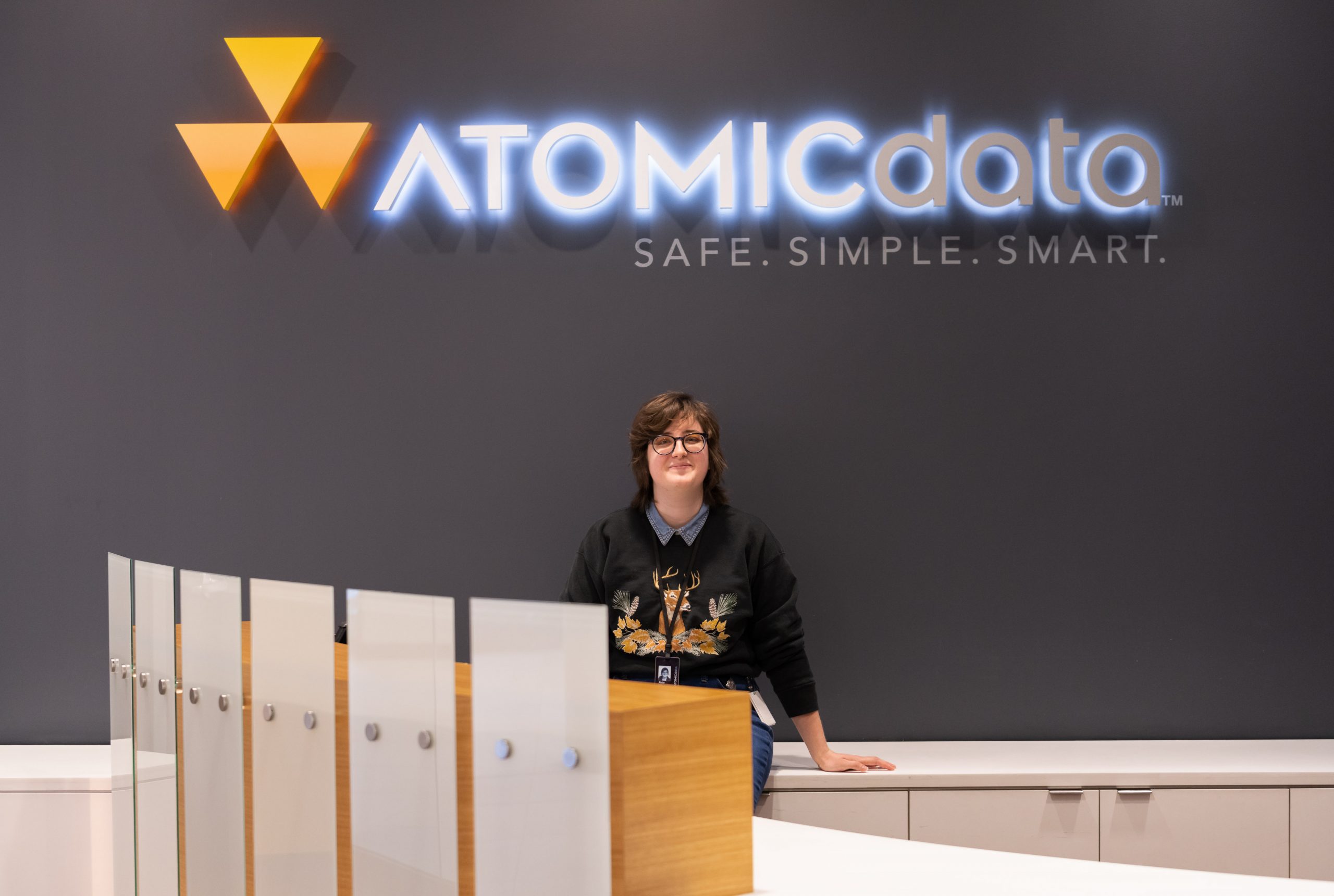 Abby Engle in front of Atomic Data sign