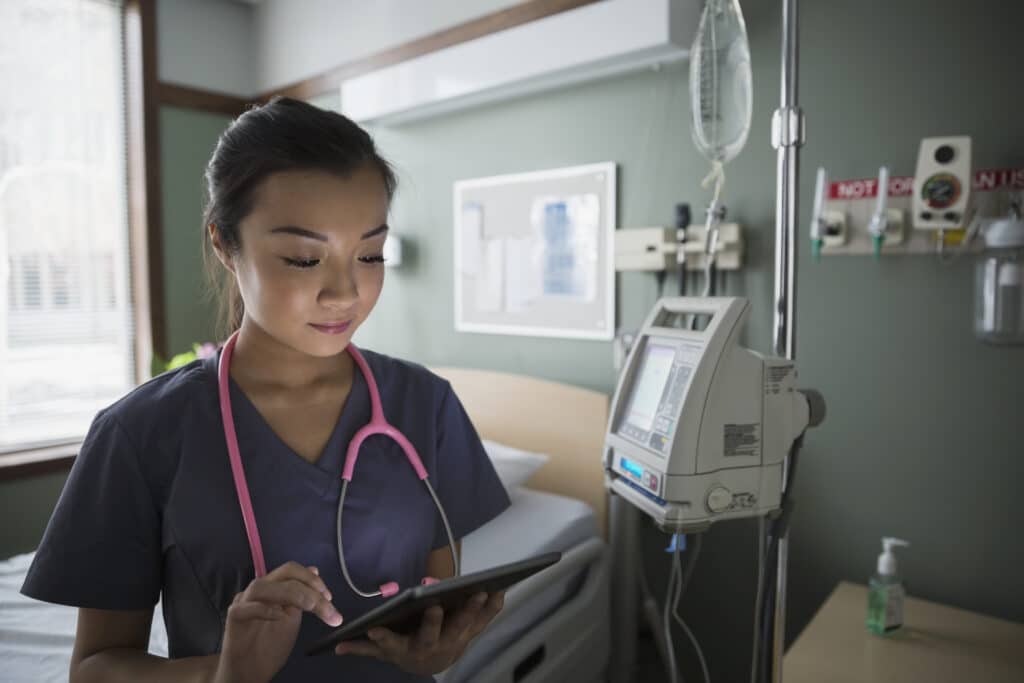 A nurse checks her tablet